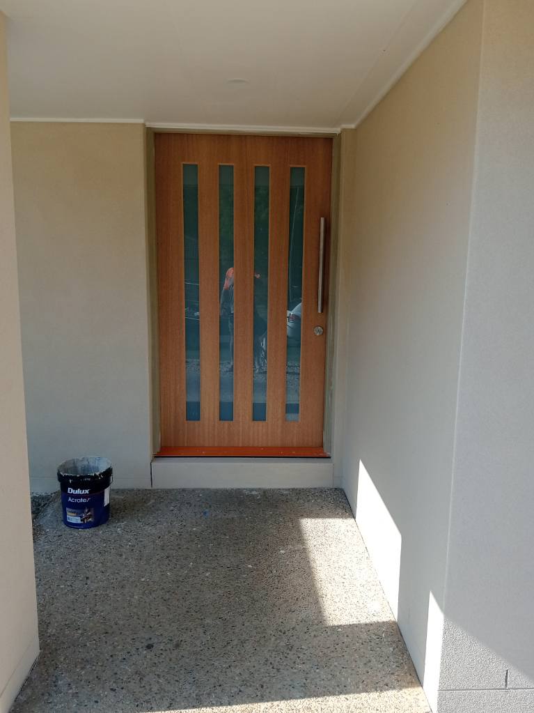 Rendered entry alcove around a timber front door