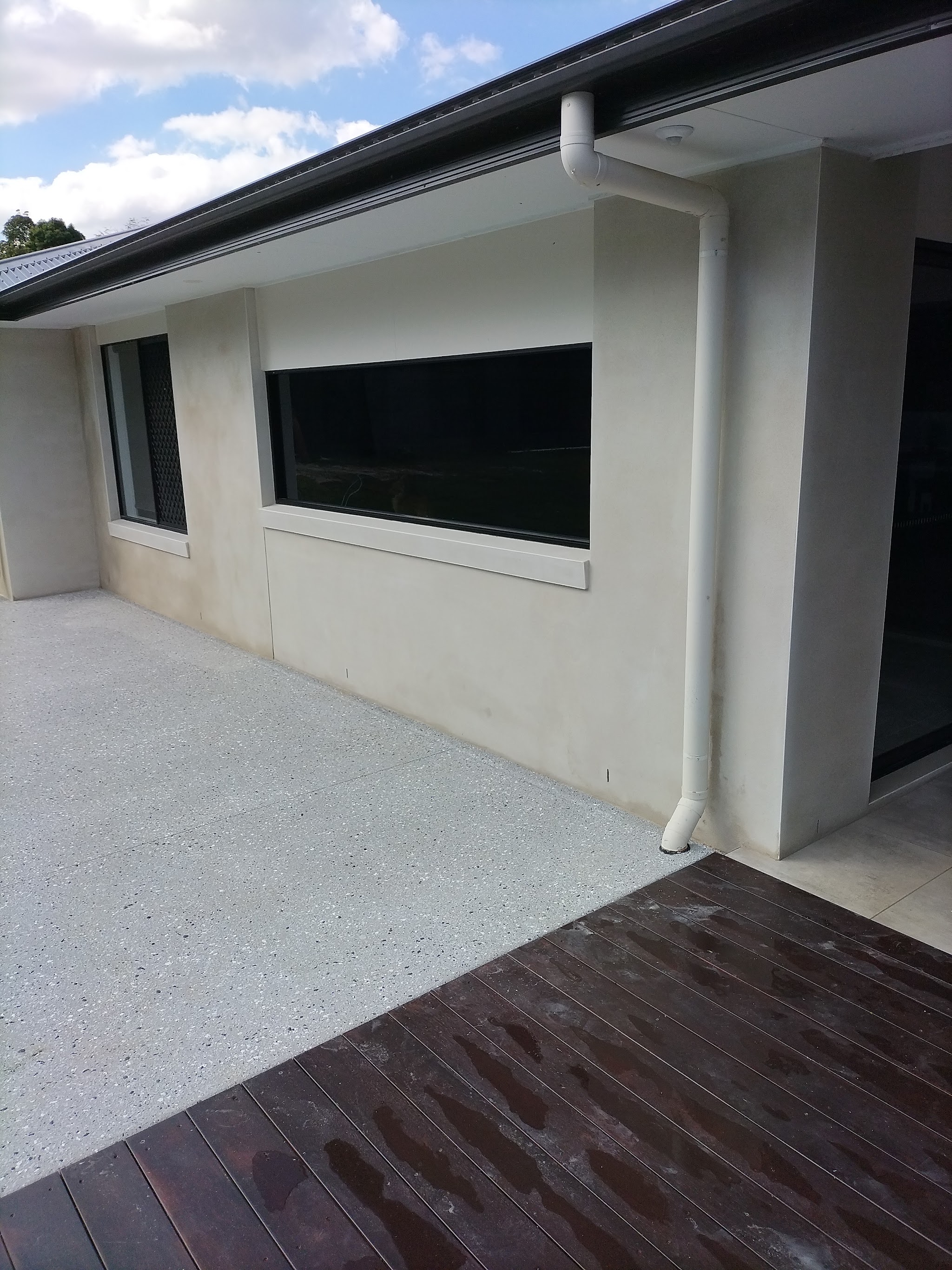 Close-up of a smooth rendered wall section with a window and downpipe